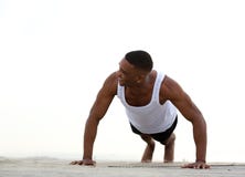 Jonge atletische mens die en duw UPS glimlachen doen royalty-vrije stock foto Jonge atletische mens die en duw UPS glimlachen doen royalty-vrije stock foto