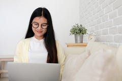 Jonge Aziatische vrouw die laptop computerzitting op bankbackgrou gebruiken royalty-vrije stock afbeeldingen Jonge Aziatische vrouw die laptop computerzitting op bankbackgrou gebruiken royalty-vrije stock afbeeldingen