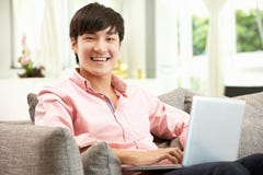 Jonge Chinese Mens die Laptop met behulp van terwijl het Ontspannen royalty-vrije stock fotografie Jonge Chinese Mens die Laptop met behulp van terwijl het Ontspannen royalty-vrije stock fotografie