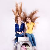 Jonge die vrouw twee en wasmachine op witte achtergrond wordt geïsoleerd royalty-vrije stock afbeelding Jonge die vrouw twee en wasmachine op witte achtergrond wordt geïsoleerd royalty-vrije stock afbeelding