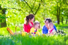 Jonge familie met jonge geitjes die picknick hebben in openlucht stock afbeeldingen Jonge familie met jonge geitjes die picknick hebben in openlucht stock afbeeldingen