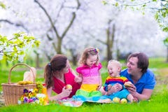 Jonge familie met jonge geitjes die picknick hebben in openlucht royalty-vrije stock foto Jonge familie met jonge geitjes die picknick hebben in openlucht royalty-vrije stock foto