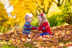 Jonge geitjes die in de herfstpark spelen Stock Afbeelding Jonge geitjes die in de herfstpark spelen Stock Afbeelding