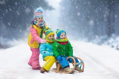 Jonge geitjesspel in sneeuw De rit van de de winterar voor kinderen royalty-vrije stock afbeelding Jonge geitjesspel in sneeuw De rit van de de winterar voor kinderen royalty-vrije stock afbeelding