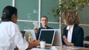 Jonge Grappige Mens in Bureau Speeldocument Vliegtuig terwijl Andere Mensen werken 4K stock footage Jonge Grappige Mens in Bureau Speeldocument Vliegtuig terwijl Andere Mensen werken 4K stock footage