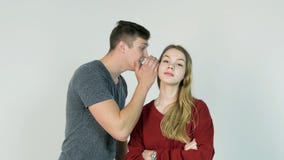 Jonge Man die een geheim fluisteren aan een verraste jonge Vrouw De jonge mens vertelt een geheim aan het meisje stock foto Jonge Man die een geheim fluisteren aan een verraste jonge Vrouw De jonge mens vertelt een geheim aan het meisje stock foto