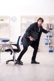 Jonge mannelijke werknemer in het concept van het bureau in time beheer stock fotografie Jonge mannelijke werknemer in het concept van het bureau in time beheer stock fotografie