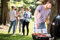 Jonge mens die barbecue doet royalty-vrije stock foto's Jonge mens die barbecue doet royalty-vrije stock foto's