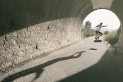 Jonge mens in tunnel met skateboard stock afbeelding Jonge mens in tunnel met skateboard stock afbeelding