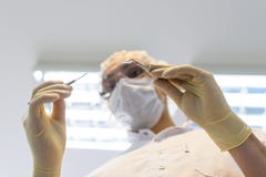 Jonge mensentandarts in beschermingshandschoenen en een masker royalty-vrije stock foto Jonge mensentandarts in beschermingshandschoenen en een masker royalty-vrije stock foto
