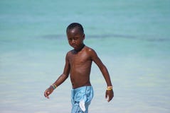 Jonge mooie zwarte jongen die op het Caraïbische strand vlak na het zwemmen lopen stock afbeeldingen Jonge mooie zwarte jongen die op het Caraïbische strand vlak na het zwemmen lopen stock afbeeldingen