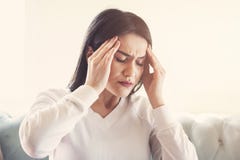 Jonge vrouw die aan sterke hoofdpijn of migrainezitting thuis lijden, millennial kerel die intoxicatie en pijn wat betreft achi v stock fotografie Jonge vrouw die aan sterke hoofdpijn of migrainezitting thuis lijden, millennial kerel die intoxicatie en pijn wat betreft achi v stock fotografie