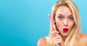 Jonge vrouw die een tandenborstel houden Stock Afbeeldingen Jonge vrouw die een tandenborstel houden Stock Afbeeldingen