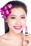 Jonge vrouw die lippenstift op lippen zetten stock afbeelding Jonge vrouw die lippenstift op lippen zetten stock afbeelding