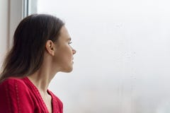 Jonge vrouw die uit het venster op een regenachtige dag, exemplaarruimte kijken royalty-vrije stock afbeelding Jonge vrouw die uit het venster op een regenachtige dag, exemplaarruimte kijken royalty-vrije stock afbeelding