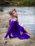 Jonge vrouw in purpere togazitting door een rivier royalty-vrije stock afbeeldingen Jonge vrouw in purpere togazitting door een rivier royalty-vrije stock afbeeldingen