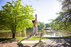 Jonge vrouw in witte hoogste het praktizeren yoga in mooie aard royalty-vrije stock foto Jonge vrouw in witte hoogste het praktizeren yoga in mooie aard royalty-vrije stock foto