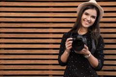 Jonge vrouwelijke fotograaf met professionele camera dichtbij houten muur royalty-vrije stock foto's Jonge vrouwelijke fotograaf met professionele camera dichtbij houten muur royalty-vrije stock foto's