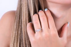 Jonge vrouwelijke hand met overeenkomstentrouwring op vinger en handholding in haar royalty-vrije stock afbeelding Jonge vrouwelijke hand met overeenkomstentrouwring op vinger en handholding in haar royalty-vrije stock afbeelding