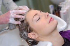 Jonge vrouwelijke vrouw die die haar hebben in schoonheidssalon wordt gewassen stock afbeelding Jonge vrouwelijke vrouw die die haar hebben in schoonheidssalon wordt gewassen stock afbeelding