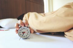 Jonge vrouwenslaap in de slaapkamer met Handvat de wekker in de ochtend, Gezondheidsconcept stock foto Jonge vrouwenslaap in de slaapkamer met Handvat de wekker in de ochtend, Gezondheidsconcept stock foto