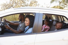 Jonge zwarte familie in een autoglimlach op de wegreis stock afbeelding Jonge zwarte familie in een autoglimlach op de wegreis stock afbeelding