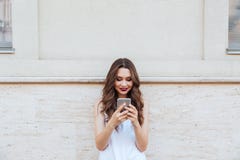 Jongelui die mooi meisje glimlachen die haar telefoon in openlucht met behulp van stock foto Jongelui die mooi meisje glimlachen die haar telefoon in openlucht met behulp van stock foto