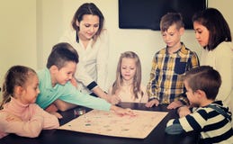 Jongens en meisjes die bij raadsspel spelen royalty-vrije stock foto Jongens en meisjes die bij raadsspel spelen royalty-vrije stock foto