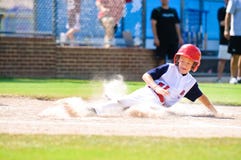 Joueur de baseball d'équipe de minimes glissant à la maison. Joueur de baseball d'équipe de minimes glissant à la maison.