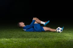Joueur de football blessé se trouvant au sol images libres de droits Joueur de football blessé se trouvant au sol images libres de droits