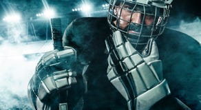 Joueur de hockey de glace dans le casque et gants sur le stade avec le bâton photographie stock Joueur de hockey de glace dans le casque et gants sur le stade avec le bâton photographie stock