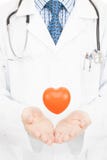 Jouez le coeur flottant en air au-dessus des paumes de médecins - concept de soins de santé image stock Jouez le coeur flottant en air au-dessus des paumes de médecins - concept de soins de santé image stock