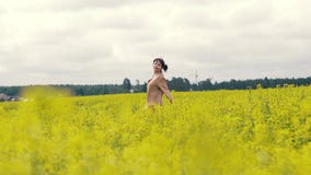 Jovem mulher alegre em uma caminhada do verão em um campo de flor filme Jovem mulher alegre em uma caminhada do verão em um campo de flor filme
