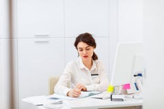 Jovem mulher amigável atrás do administrador da mesa de recepção Imagem de Stock Jovem mulher amigável atrás do administrador da mesa de recepção Imagem de Stock
