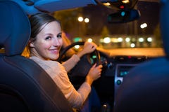 Jovem mulher bonita que conduz o carro na noite imagem de stock royalty free Jovem mulher bonita que conduz o carro na noite imagem de stock royalty free