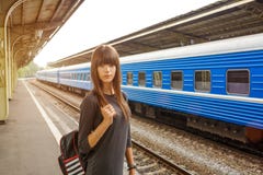 Jovem mulher bonita que está na plataforma da estação de trem foto de stock royalty free Jovem mulher bonita que está na plataforma da estação de trem foto de stock royalty free
