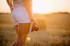 Jovem mulher bonita que guarda uma câmera do vintage a nível anca foto de stock Jovem mulher bonita que guarda uma câmera do vintage a nível anca foto de stock