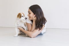Jovem mulher bonita que joga com seu cão bonito pequeno em casa Retrato do estilo de vida Amor para o conceito dos animais Fundo imagens de stock royalty free Jovem mulher bonita que joga com seu cão bonito pequeno em casa Retrato do estilo de vida Amor para o conceito dos animais Fundo imagens de stock royalty free