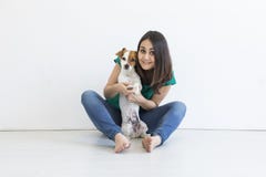 Jovem mulher bonita que joga com seu cão bonito pequeno em casa Retrato do estilo de vida Amor para o conceito dos animais Fundo foto de stock royalty free Jovem mulher bonita que joga com seu cão bonito pequeno em casa Retrato do estilo de vida Amor para o conceito dos animais Fundo foto de stock royalty free