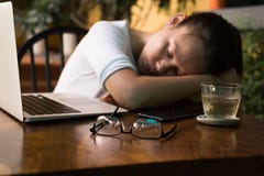 Jovem mulher cansado que dorme em sua mesa do computador imagens de stock royalty free Jovem mulher cansado que dorme em sua mesa do computador imagens de stock royalty free