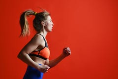 Jovem mulher com salto e corredor aptos do corpo contra o fundo vermelho fotos de stock Jovem mulher com salto e corredor aptos do corpo contra o fundo vermelho fotos de stock