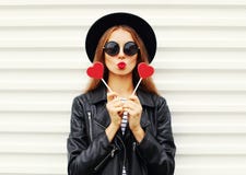 Jovem mulher consideravelmente doce da forma com os bordos vermelhos que fazem o beijo do ar com o casaco de cabedal vestindo do Fotos de Stock Royalty Free Jovem mulher consideravelmente doce da forma com os bordos vermelhos que fazem o beijo do ar com o casaco de cabedal vestindo do Fotos de Stock Royalty Free