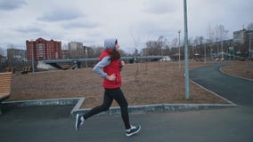 A jovem mulher corre no parque no dia nebuloso vídeos de arquivo A jovem mulher corre no parque no dia nebuloso vídeos de arquivo