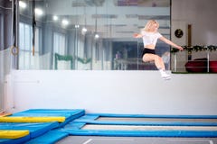 Jovem mulher de salto da guita no trampolim foto de stock Jovem mulher de salto da guita no trampolim foto de stock