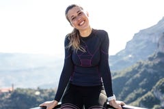 Jovem mulher desportiva que olha a câmera no pico de montanha imagens de stock royalty free Jovem mulher desportiva que olha a câmera no pico de montanha imagens de stock royalty free