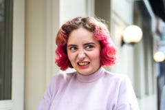 Jovem mulher emocional com cabelo ondulado cor-de-rosa com uma careta da negligência ou da raiva fotografia de stock royalty free Jovem mulher emocional com cabelo ondulado cor-de-rosa com uma careta da negligência ou da raiva fotografia de stock royalty free