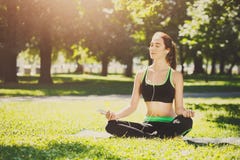 A jovem mulher fora, relaxa a pose da meditação fotografia de stock A jovem mulher fora, relaxa a pose da meditação fotografia de stock