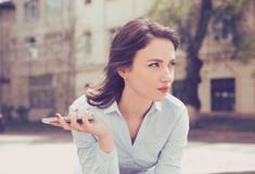 Jovem mulher frustrante que espera um telefonema de seu noivo que senta-se fora na rua Imagens de Stock Royalty Free Jovem mulher frustrante que espera um telefonema de seu noivo que senta-se fora na rua Imagens de Stock Royalty Free