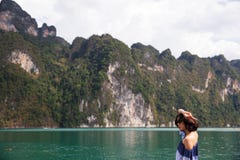 Jovem mulher no pano do verão que está e que olha ao oceano imagens de stock royalty free Jovem mulher no pano do verão que está e que olha ao oceano imagens de stock royalty free