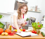 Jovem mulher que cozinha na cozinha Alimento saudável - Sal vegetal foto de stock Jovem mulher que cozinha na cozinha Alimento saudável - Sal vegetal foto de stock